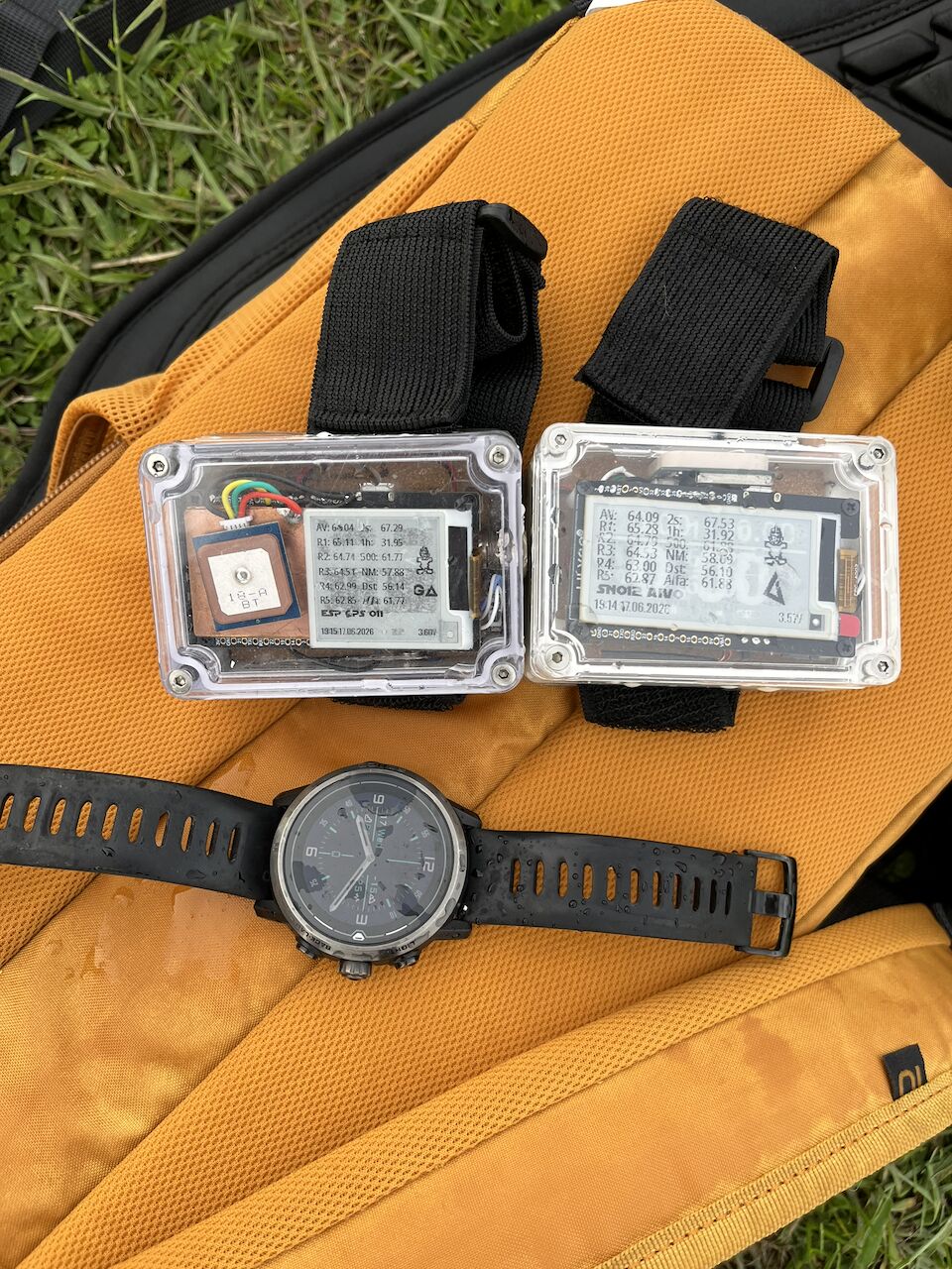 Two ESPc Loggers with arm straps on an orange bag outdoors